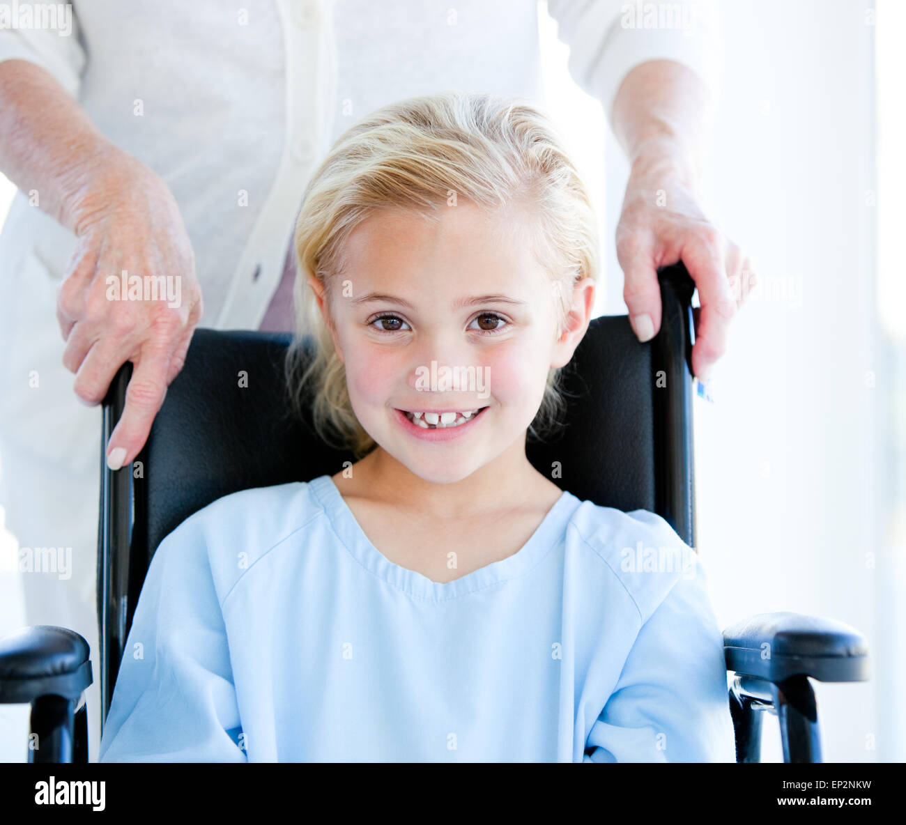Adorable little girl sitting on a wheelchair Stock Photo