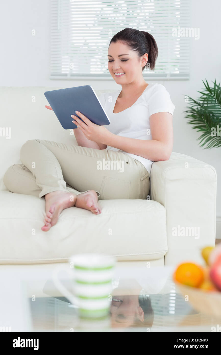 Sitting woman in the living room using a tablet pc Stock Photo - Alamy