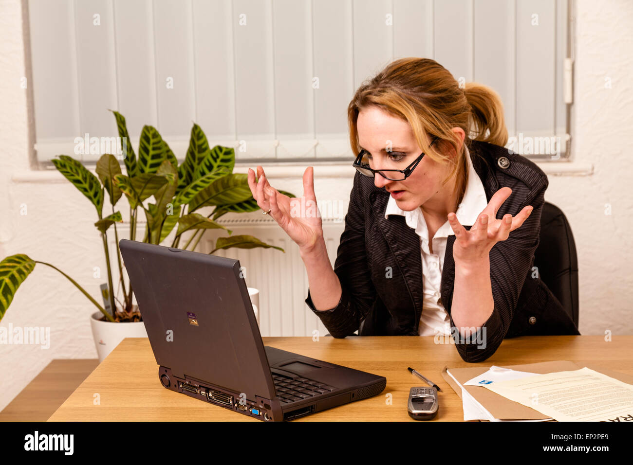 Young woman angry with her laptop Stock Photo