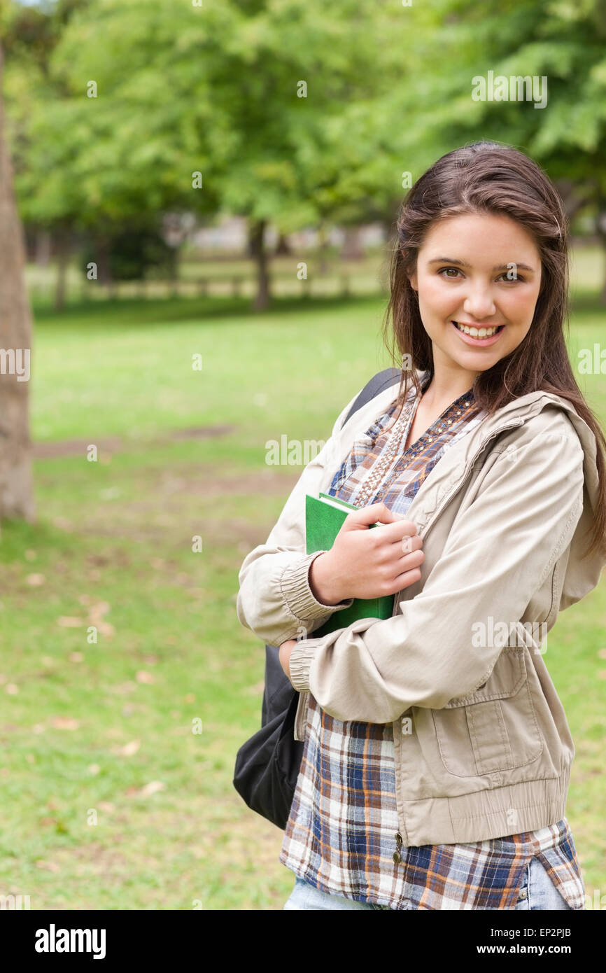 Portrait of a young smiling student holding textbook Stock Photo - Alamy
