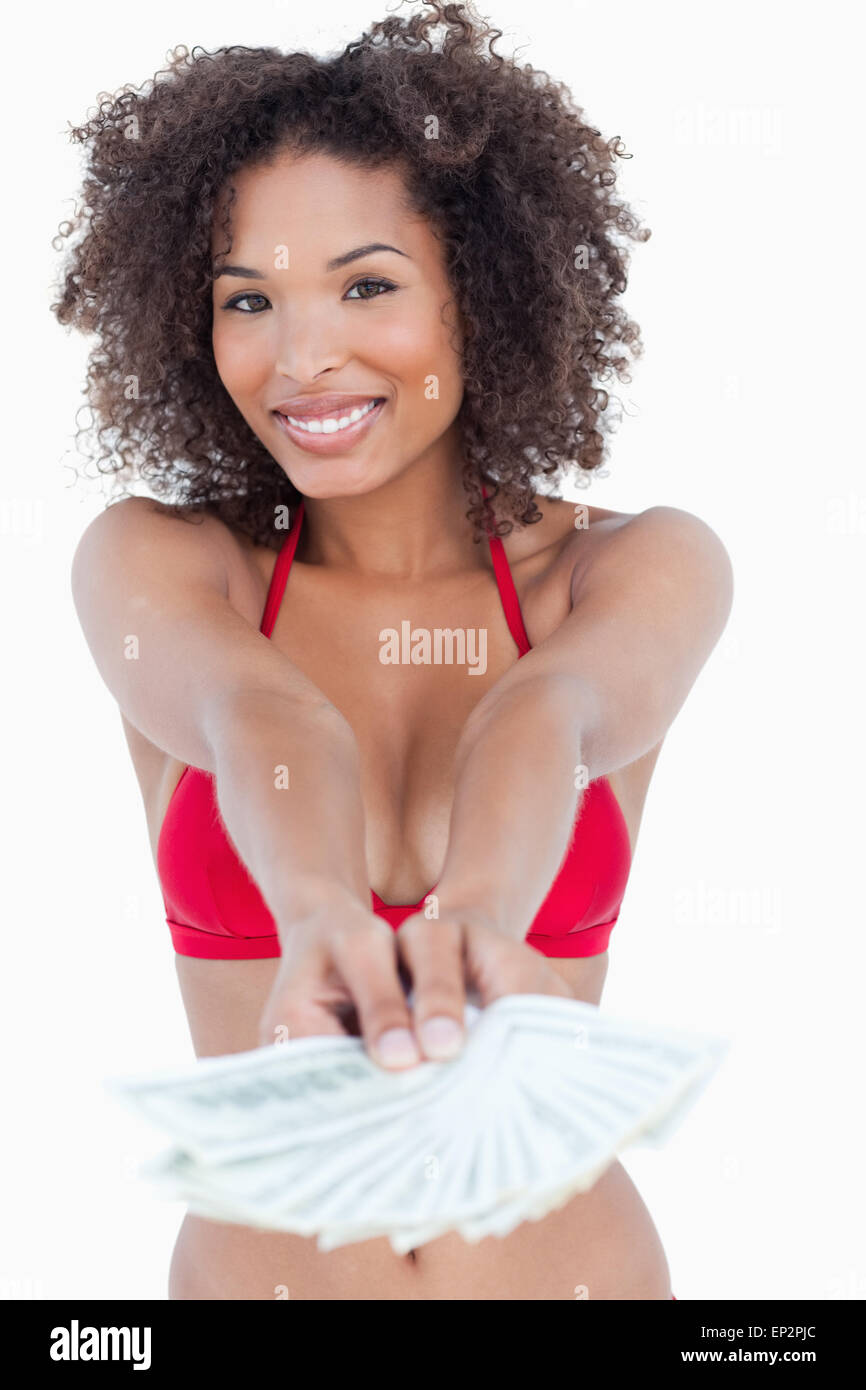 Smiling brunette woman standing upright while holding bank notes Stock Photo