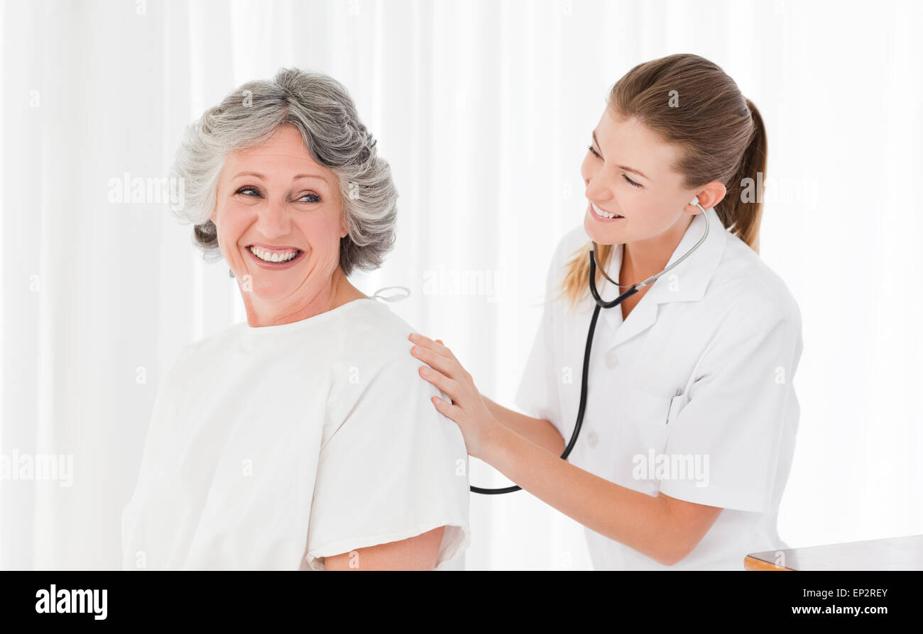 Pretty nurse taking the heartbeat of her patient Stock Photo - Alamy