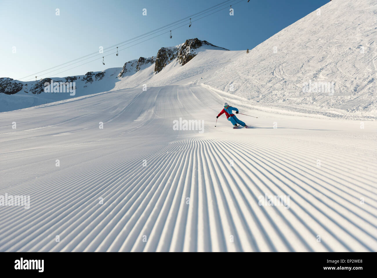 Squaw Valley skier with beautiful groomed snow beneath the palisades on Siberia Lift at Squaw Valley Ski Resort, CA Stock Photo