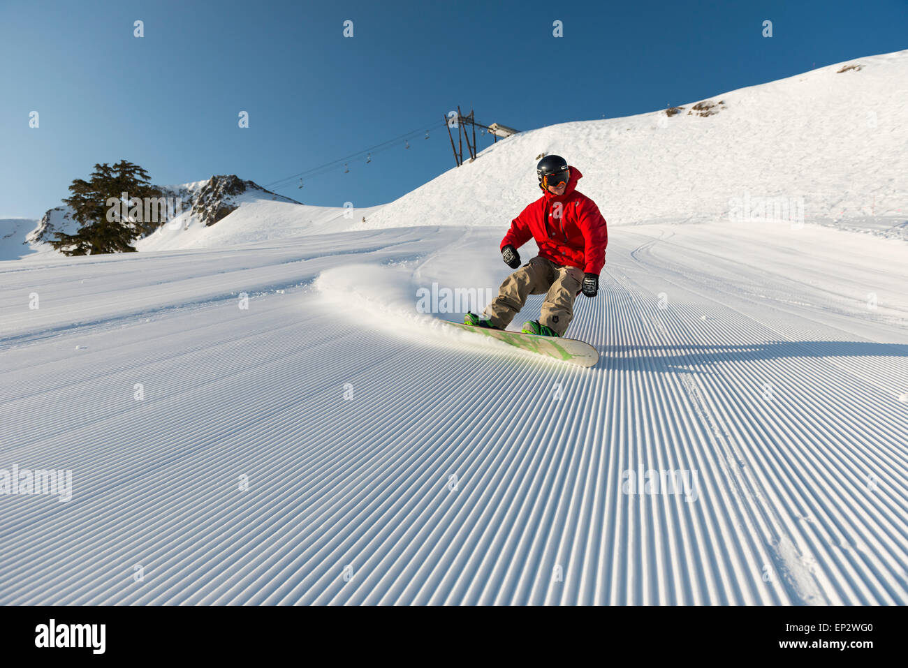 Male snowboarder on groomed run on a perfect bluebird day at Squaw Valley Ski resort in Lake Tahoe, Stock Photo