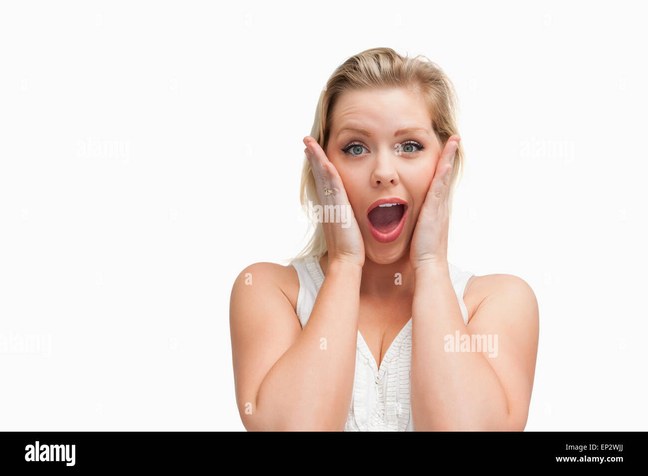 Surprised blonde woman putting her hands on her cheeks Stock Photo