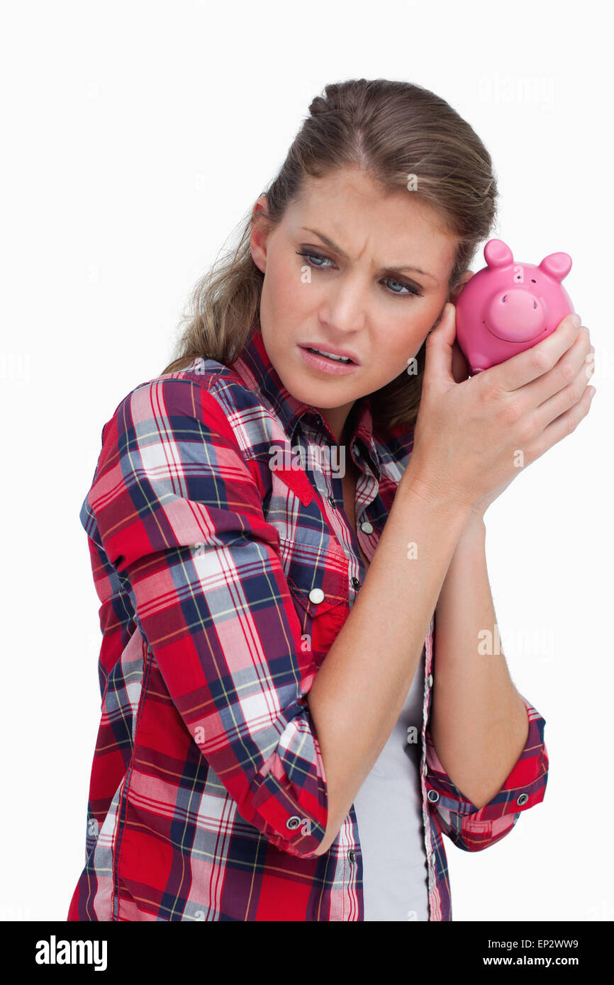 Portrait of a sad woman shaking a piggy bank Stock Photo - Alamy