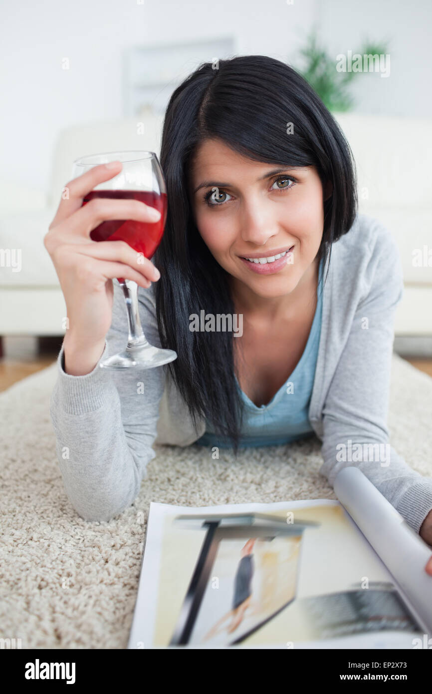 Woman smiling while holding a magazine and a glass of red wine Stock ...