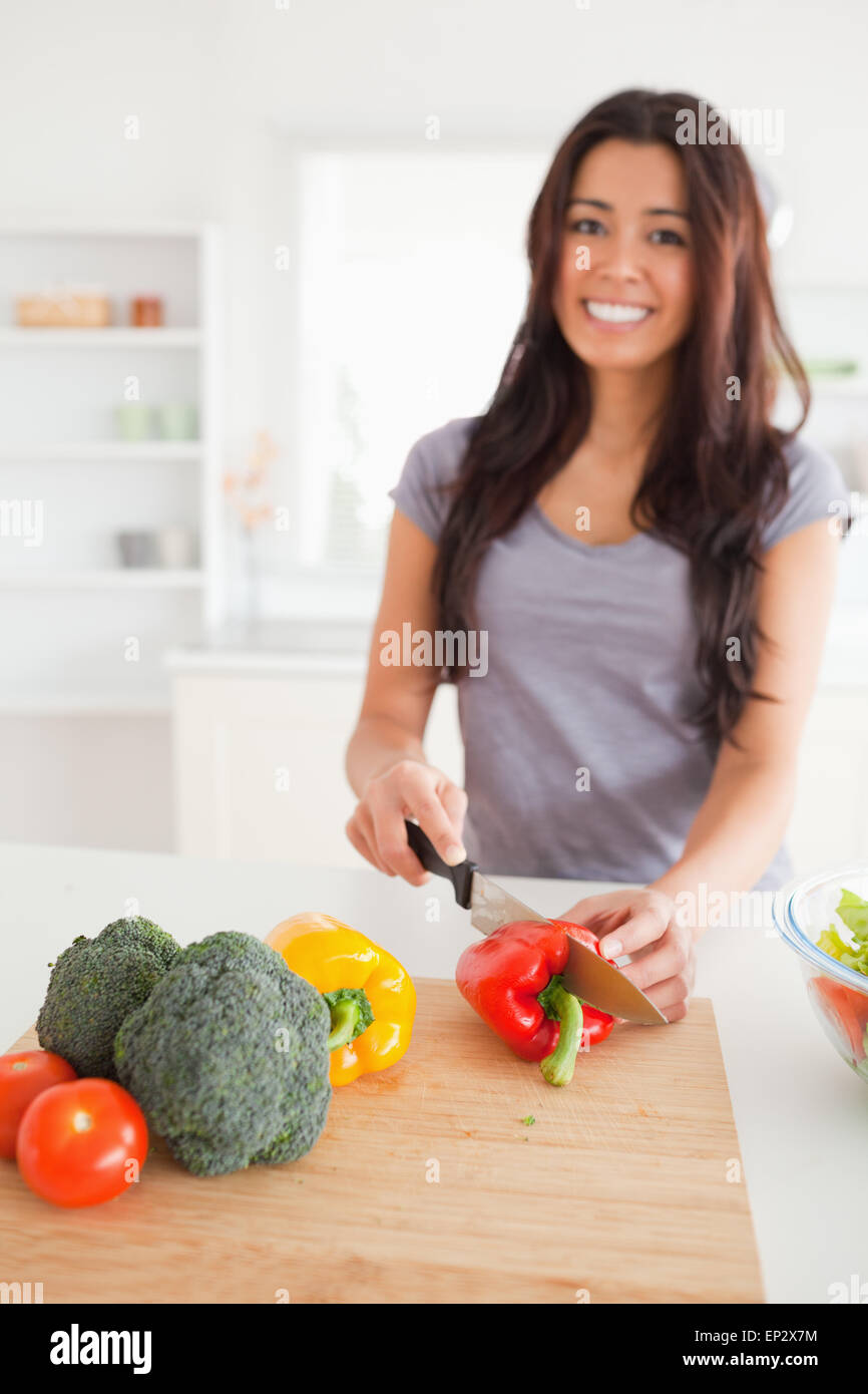 Pretty female cooking vegetables while standing Stock Photo - Alamy