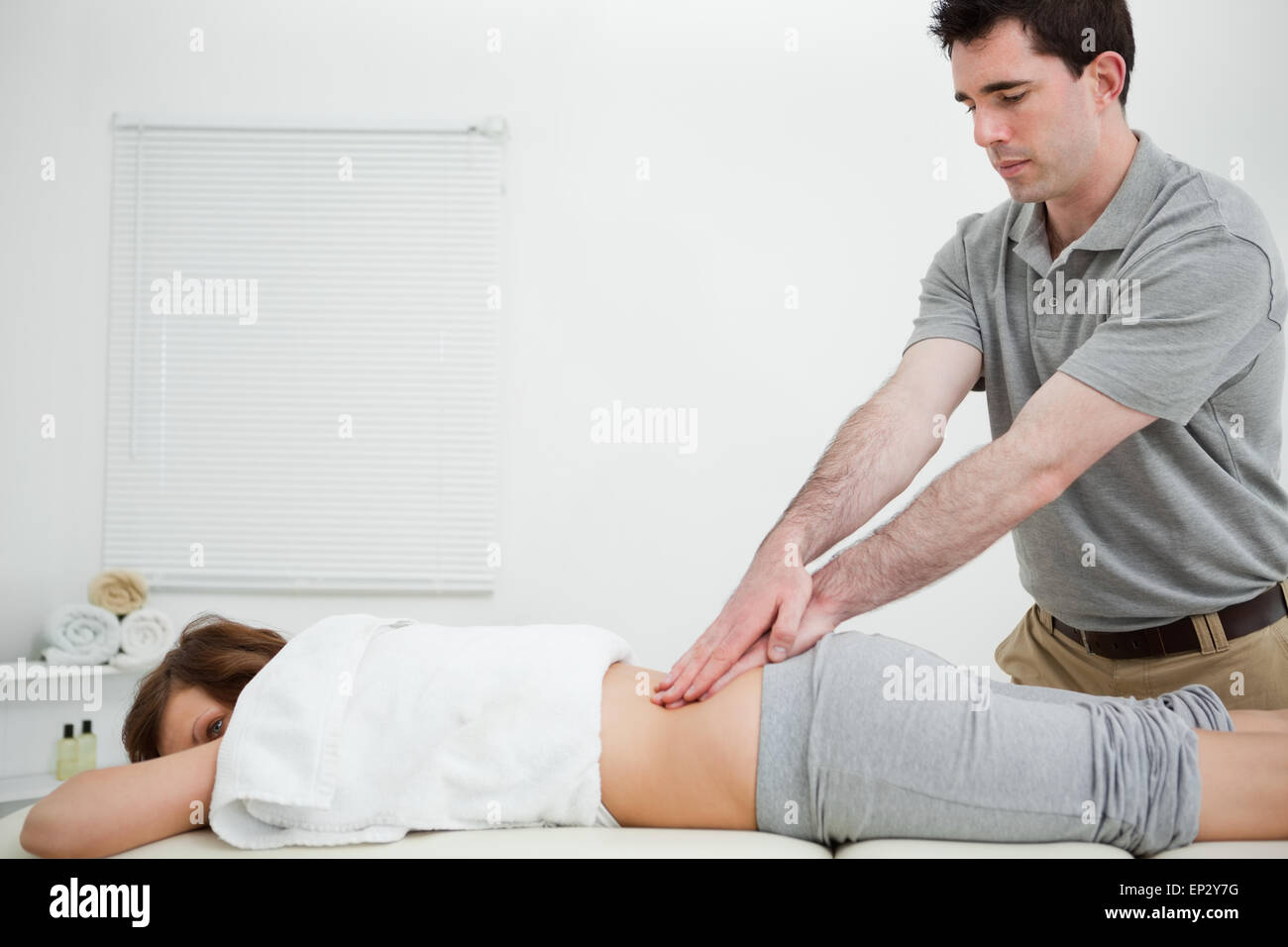 Man standing while massaging the back of a woman Stock Photo - Alamy