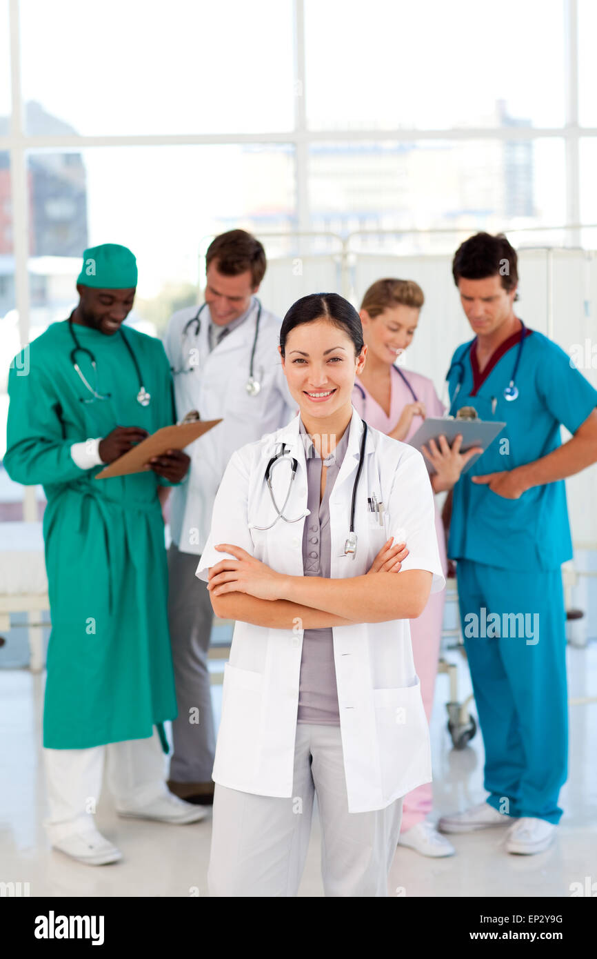 Smiling female doctor with her team Stock Photo - Alamy