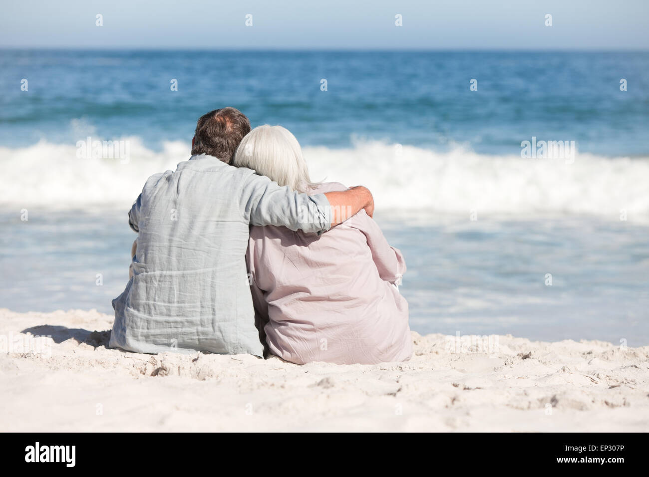 Senior couple sitting on the beach Stock Photo - Alamy