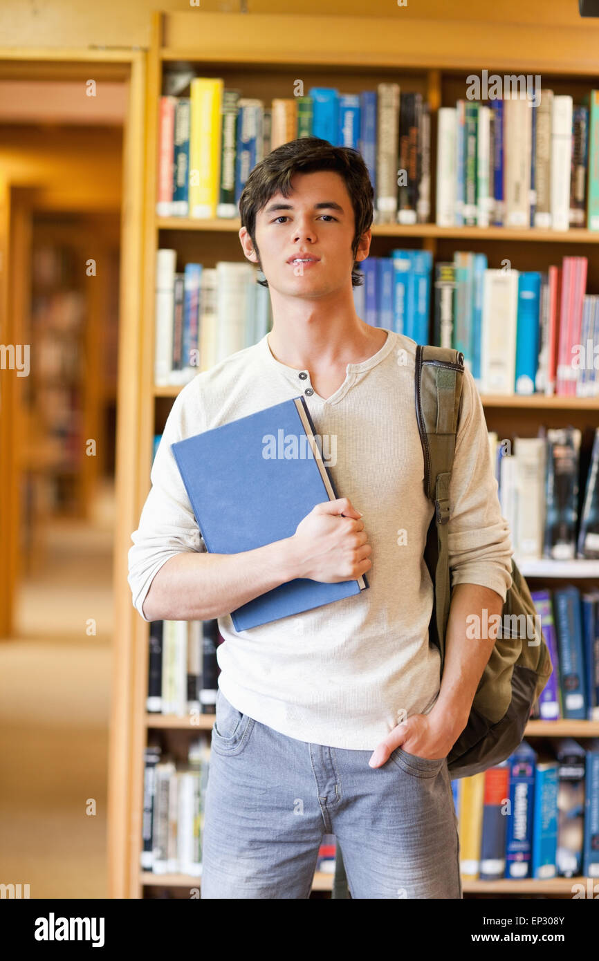 Smiling student posing with a book Stock Photo - Alamy
