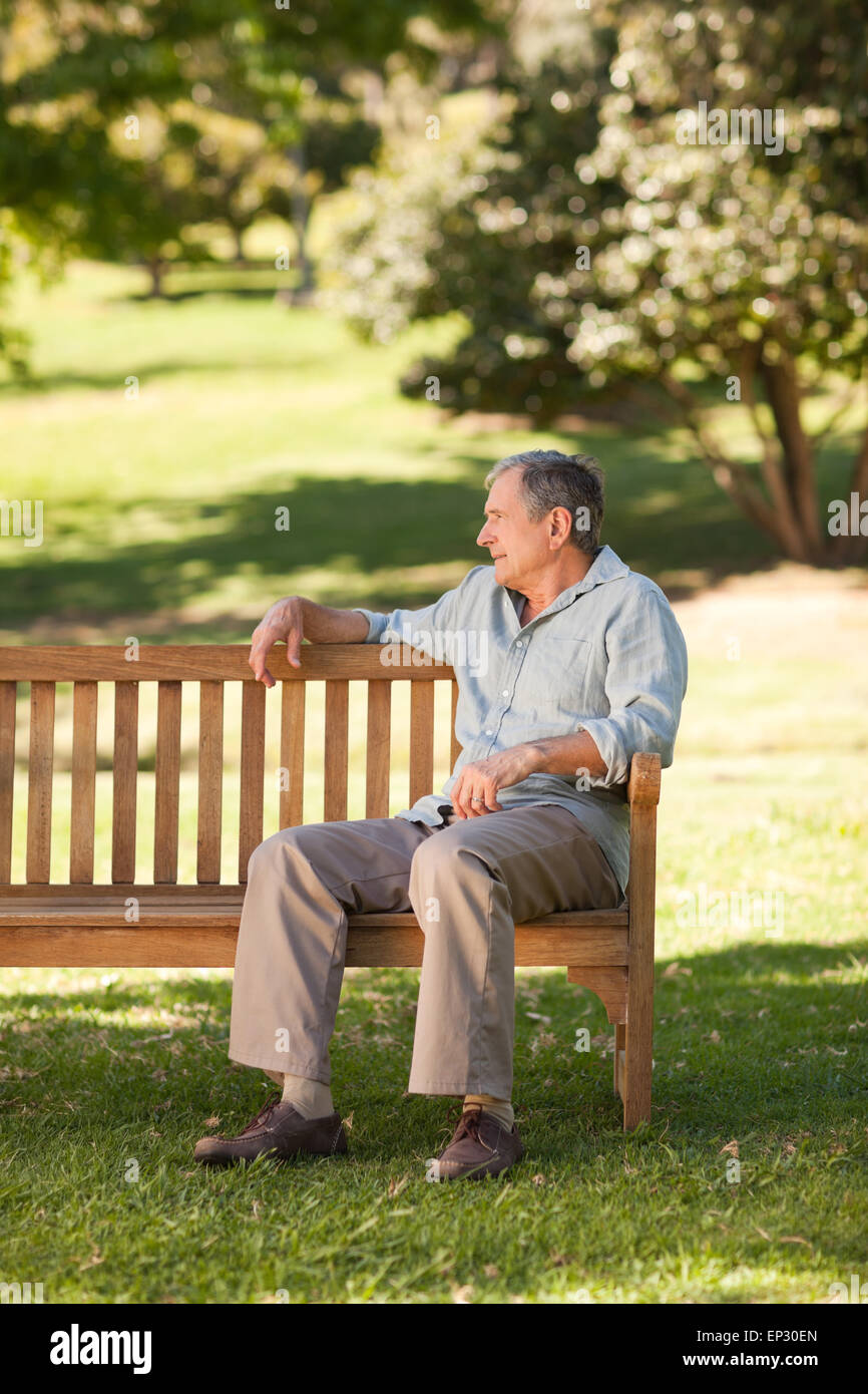 Elderly man sitting on a bench Stock Photo - Alamy