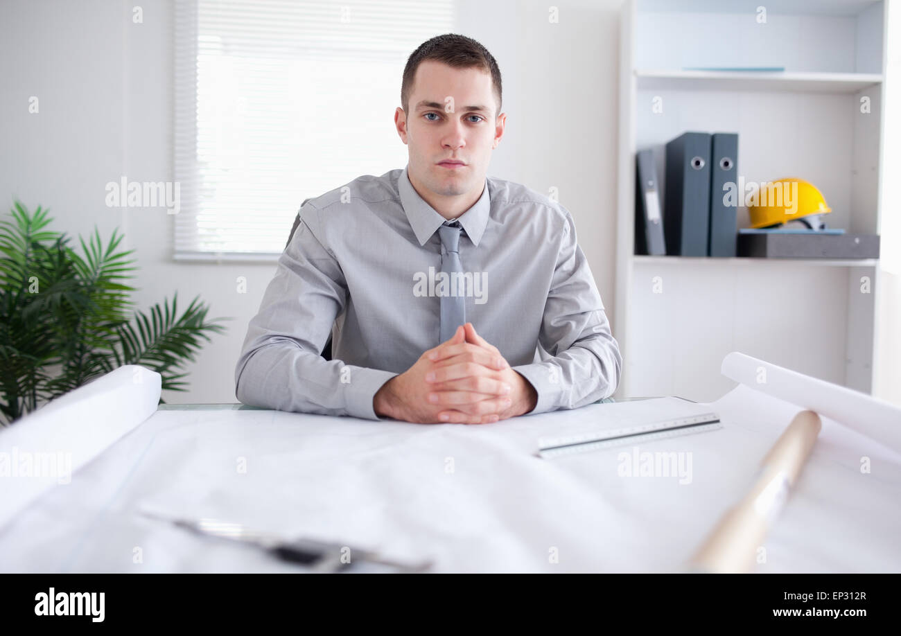Architect sitting behind a table Stock Photo - Alamy