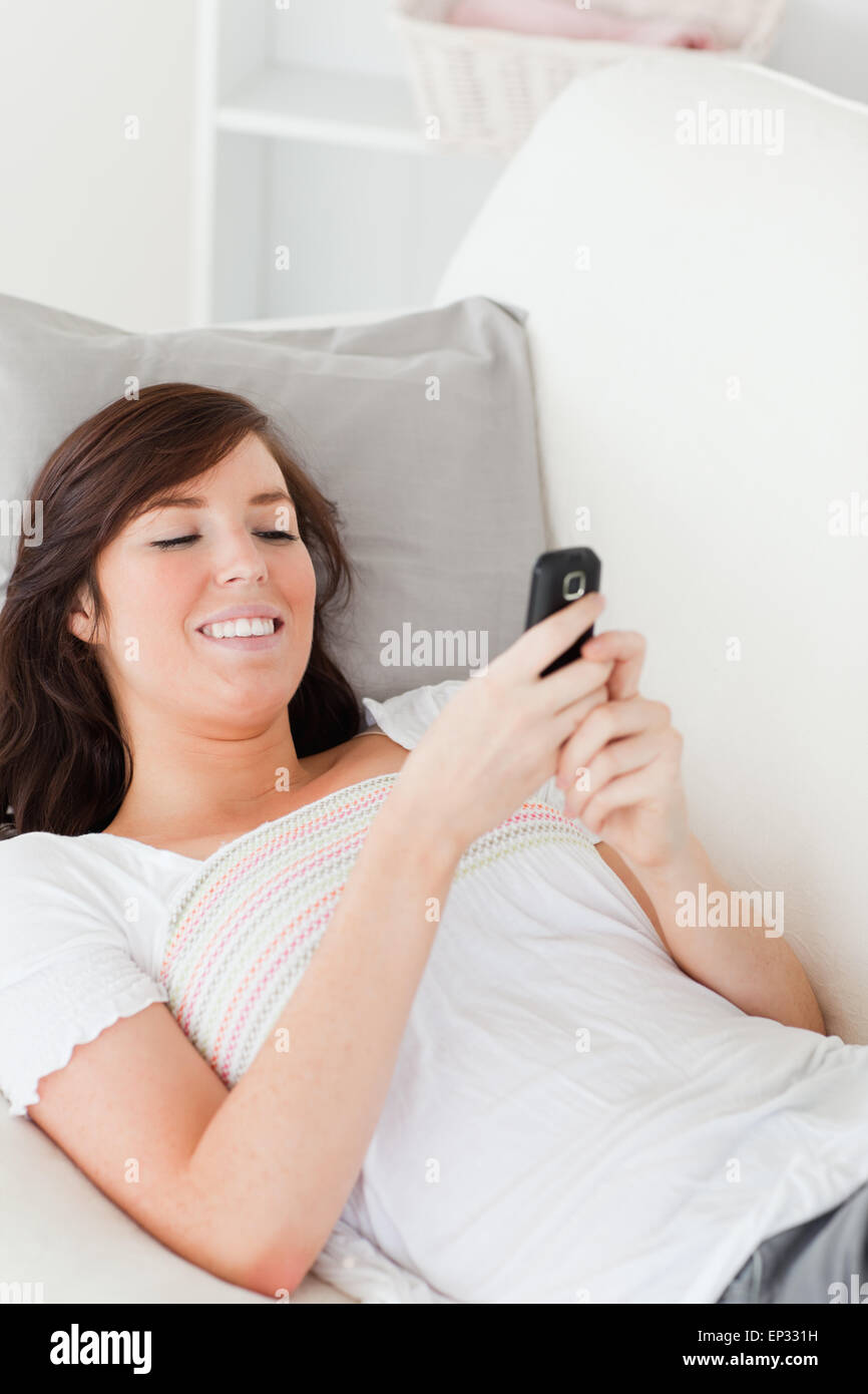 Charming brunette female writing a text on her mobile Stock Photo - Alamy