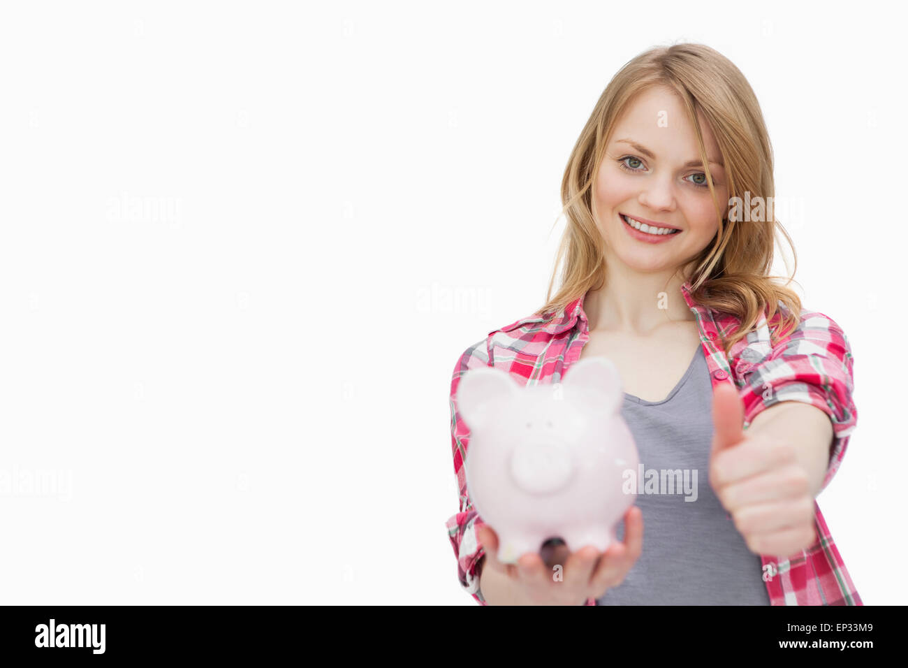 Woman with thumb up while holding a piggy bank Stock Photo - Alamy