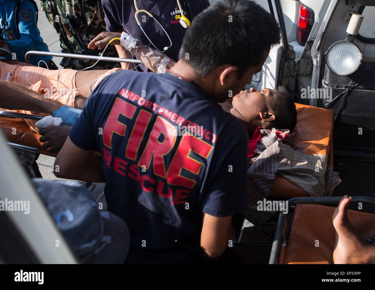 Kathmandu, Nepal. 13th May, 2015. An earthquake victim is loaded into an ambulance at a medical triage area at Tribhuvan International Airport May 12, 2015 in Kathmandu, Nepal. A 7.3 magnitude aftershock earthquake struck the kingdom following the 7.8 magnitude earthquake on April 25th. Stock Photo
