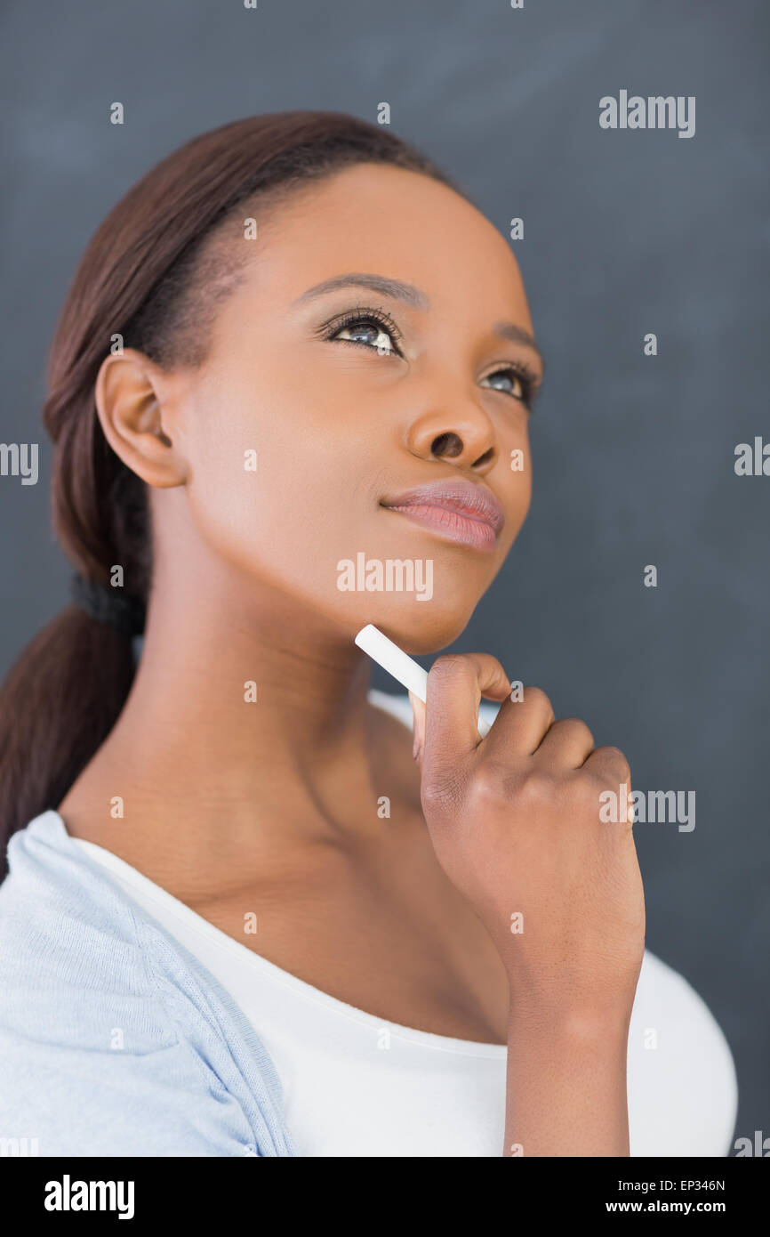 Black woman looking up while holding a chalk Stock Photo - Alamy