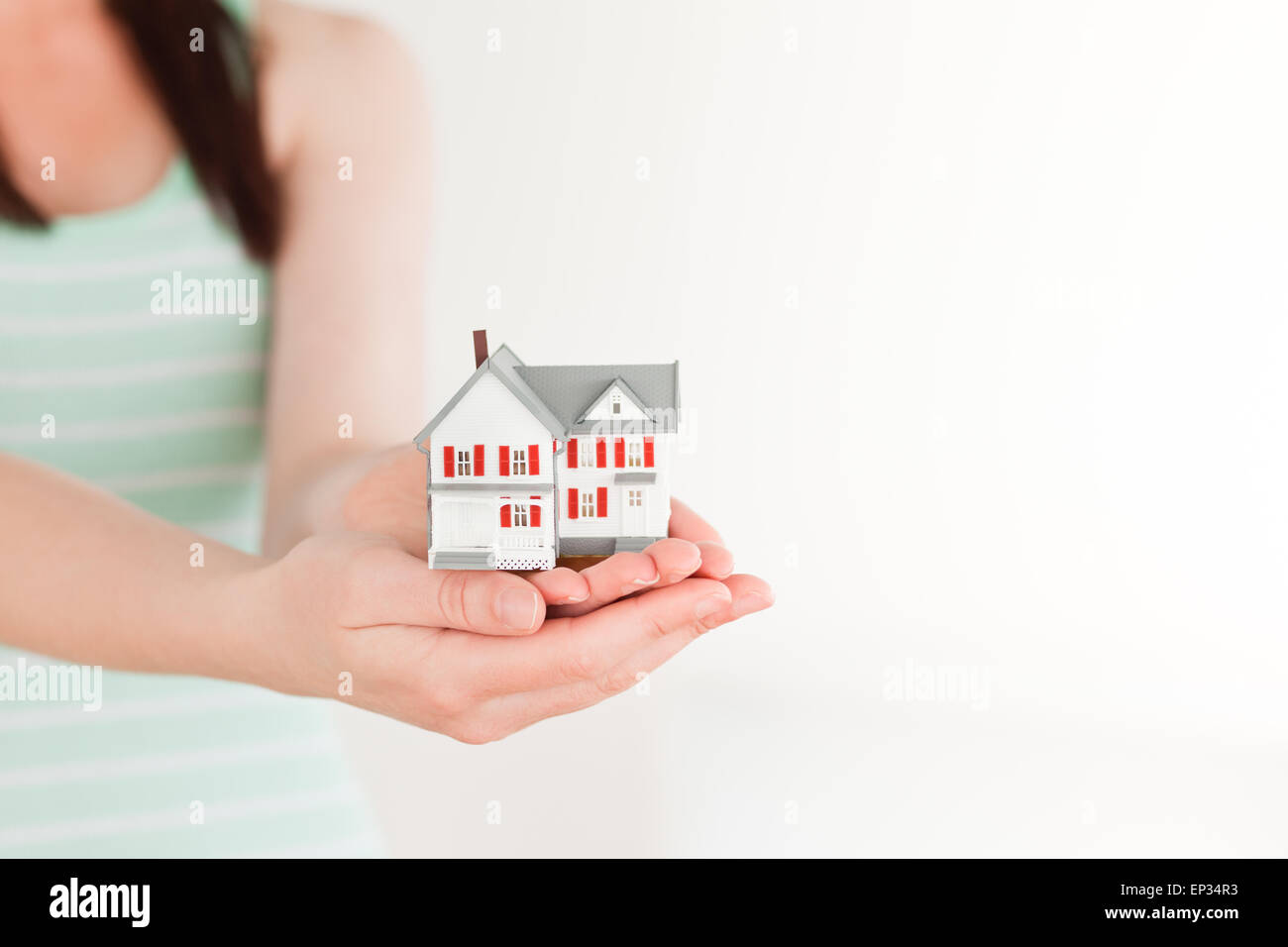 Female holding a miniature house while standing Stock Photo - Alamy