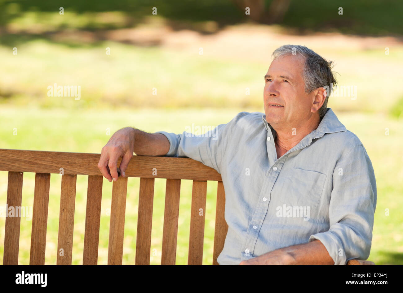 Elderly man sitting on a bench Stock Photo - Alamy