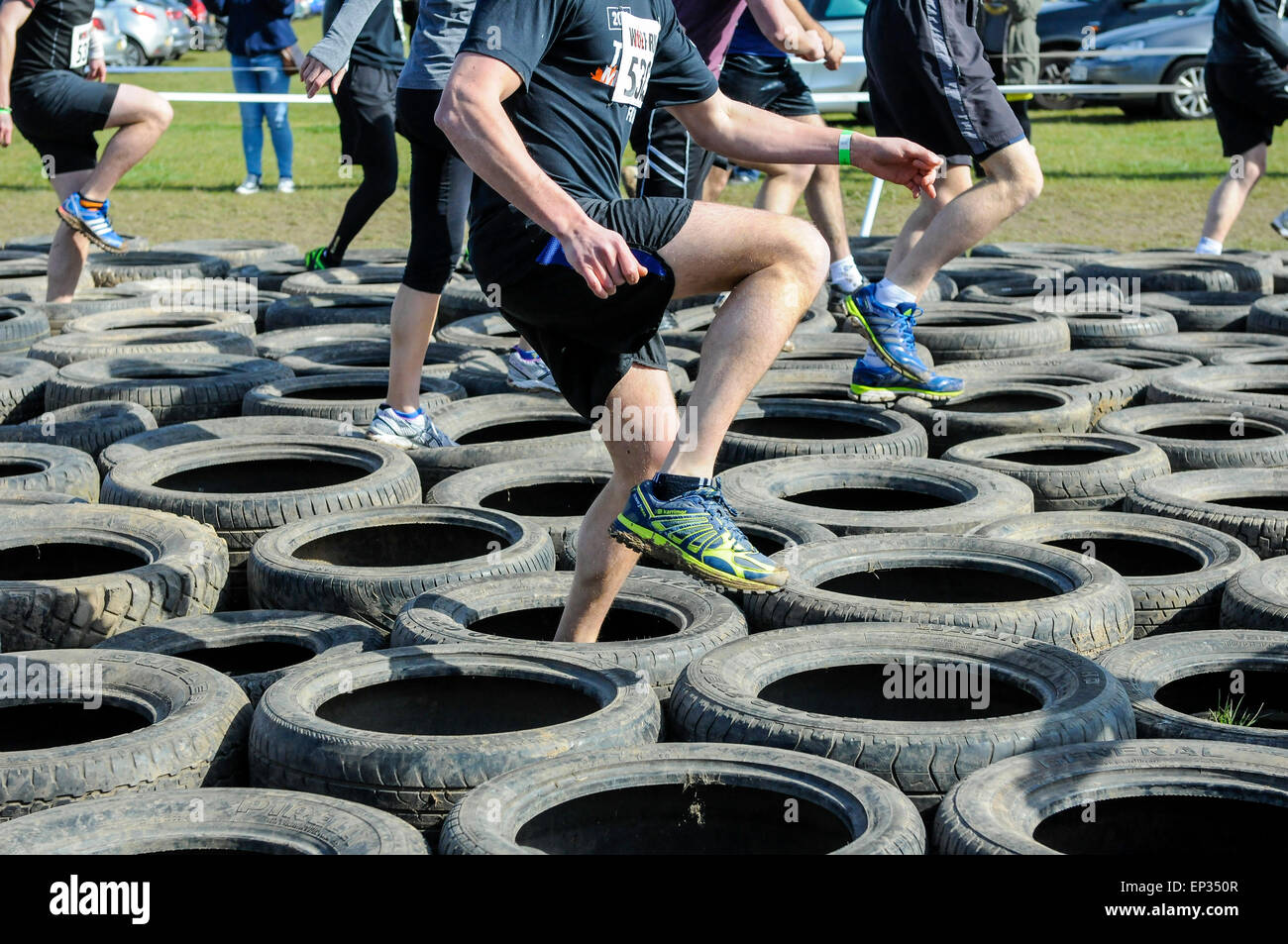 Brightly colored running shoes on rubber tyres, obstacle course race Stock Photo