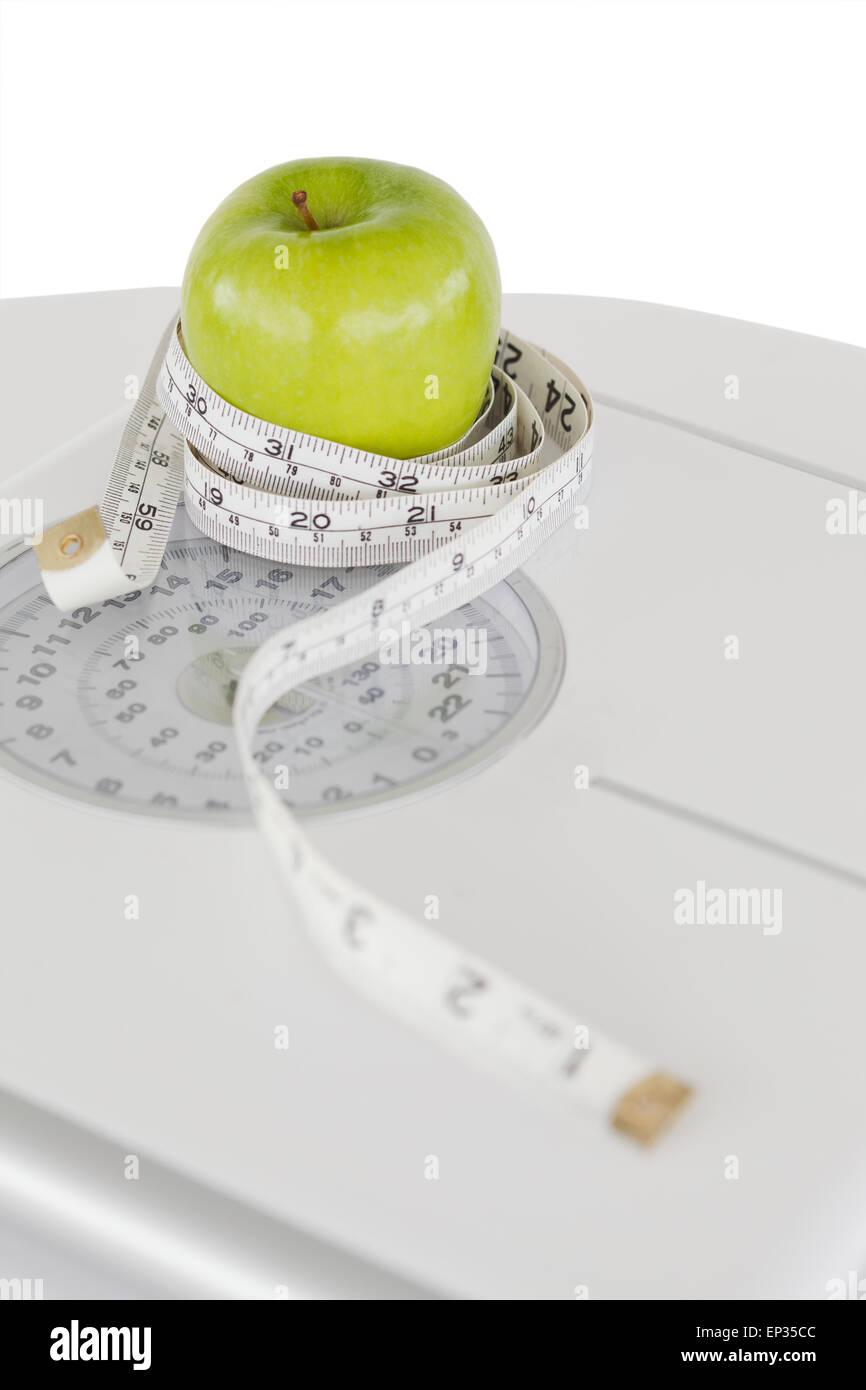 Green apple circled with a tape measure and a weighscale Stock Photo