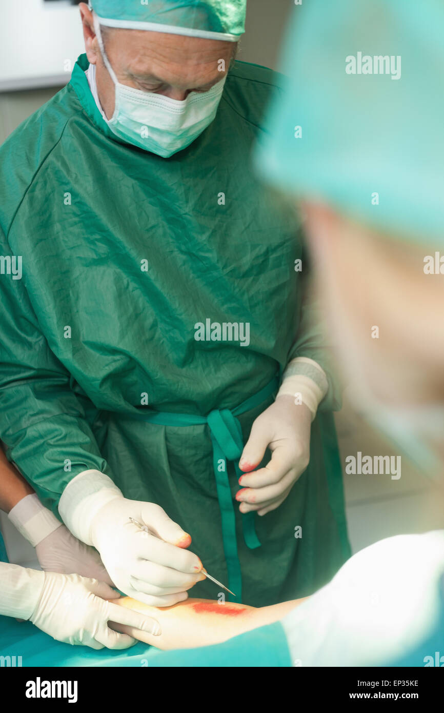 Surgeon using a scalpel to cut the skin of a patient Stock Photo Alamy