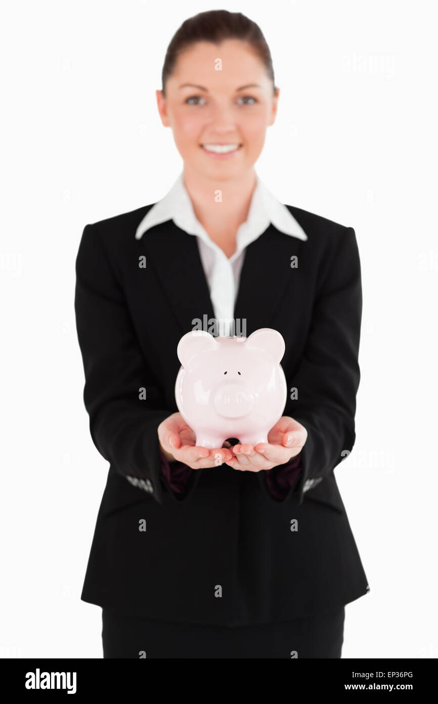 Beautiful woman in suit holding a pink piggy bank Stock Photo - Alamy
