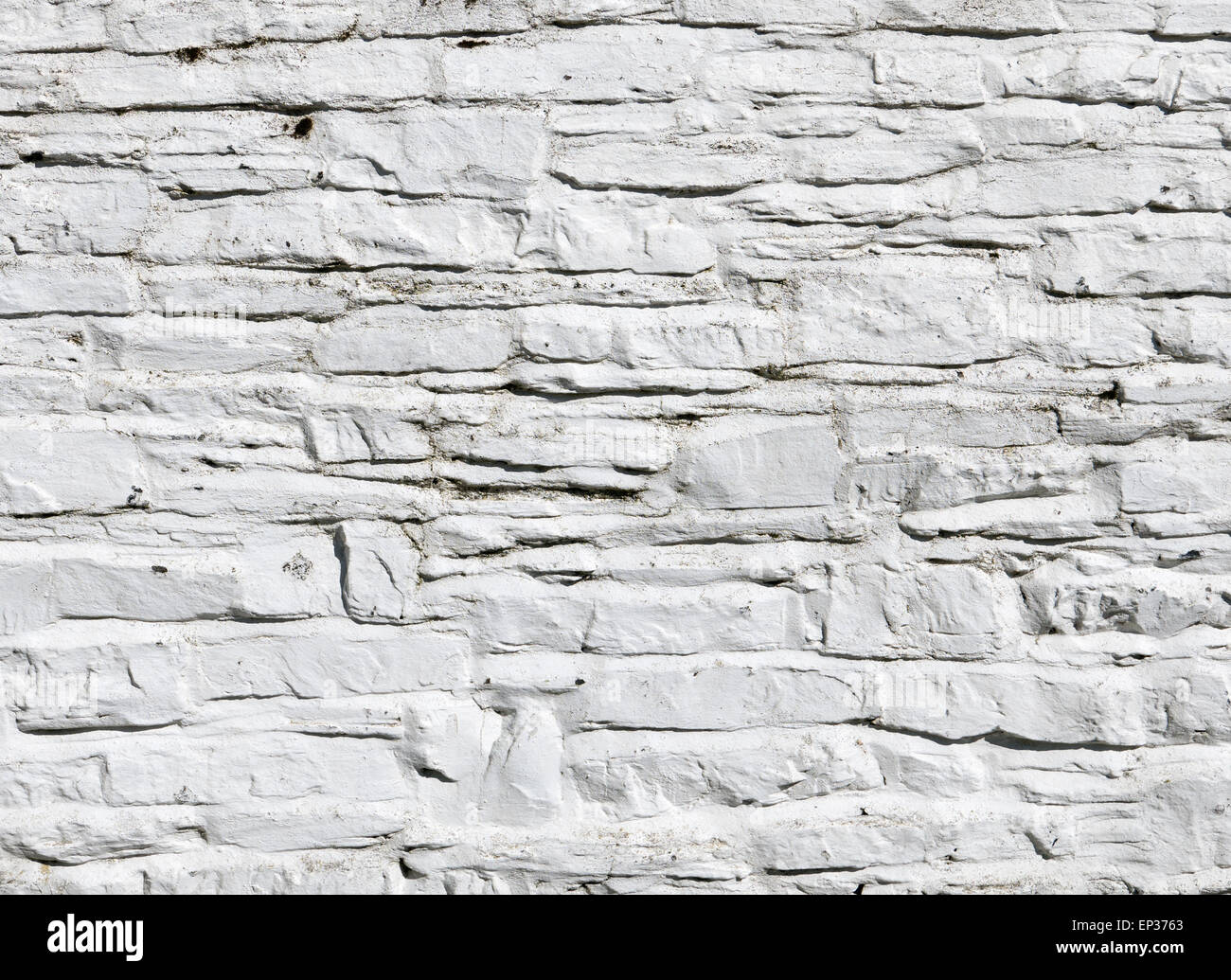 Whitewashed white paint on stone wall close up. Stock Photo
