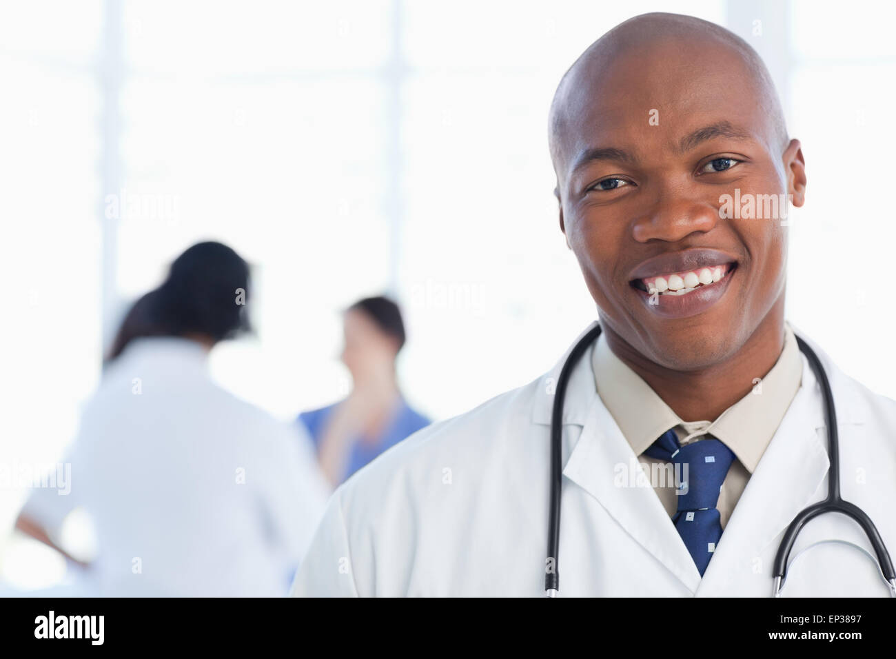 Smiling doctor standing with his stethoscope around his neck Stock