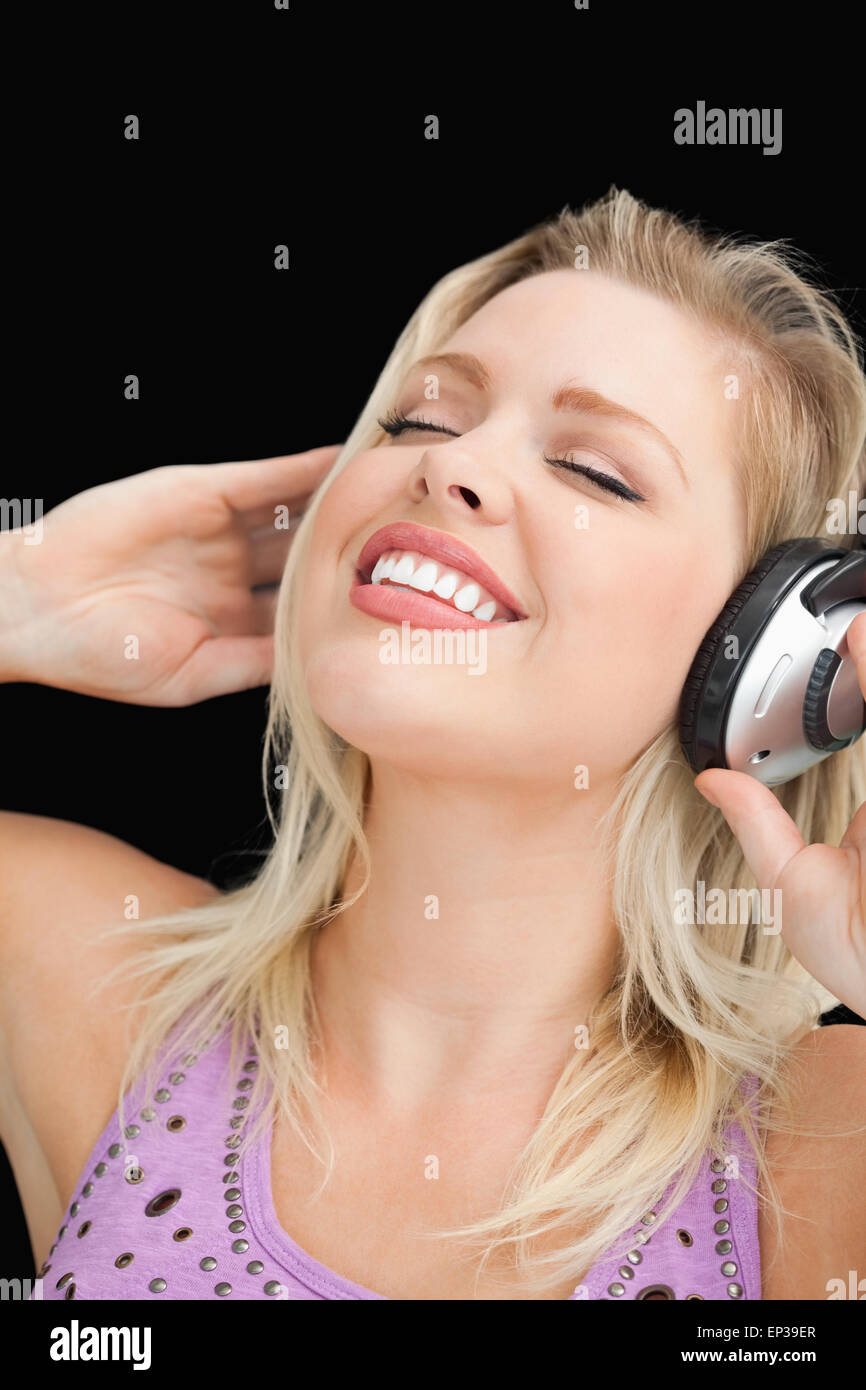Joyful blonde woman listening to music with headphones Stock Photo