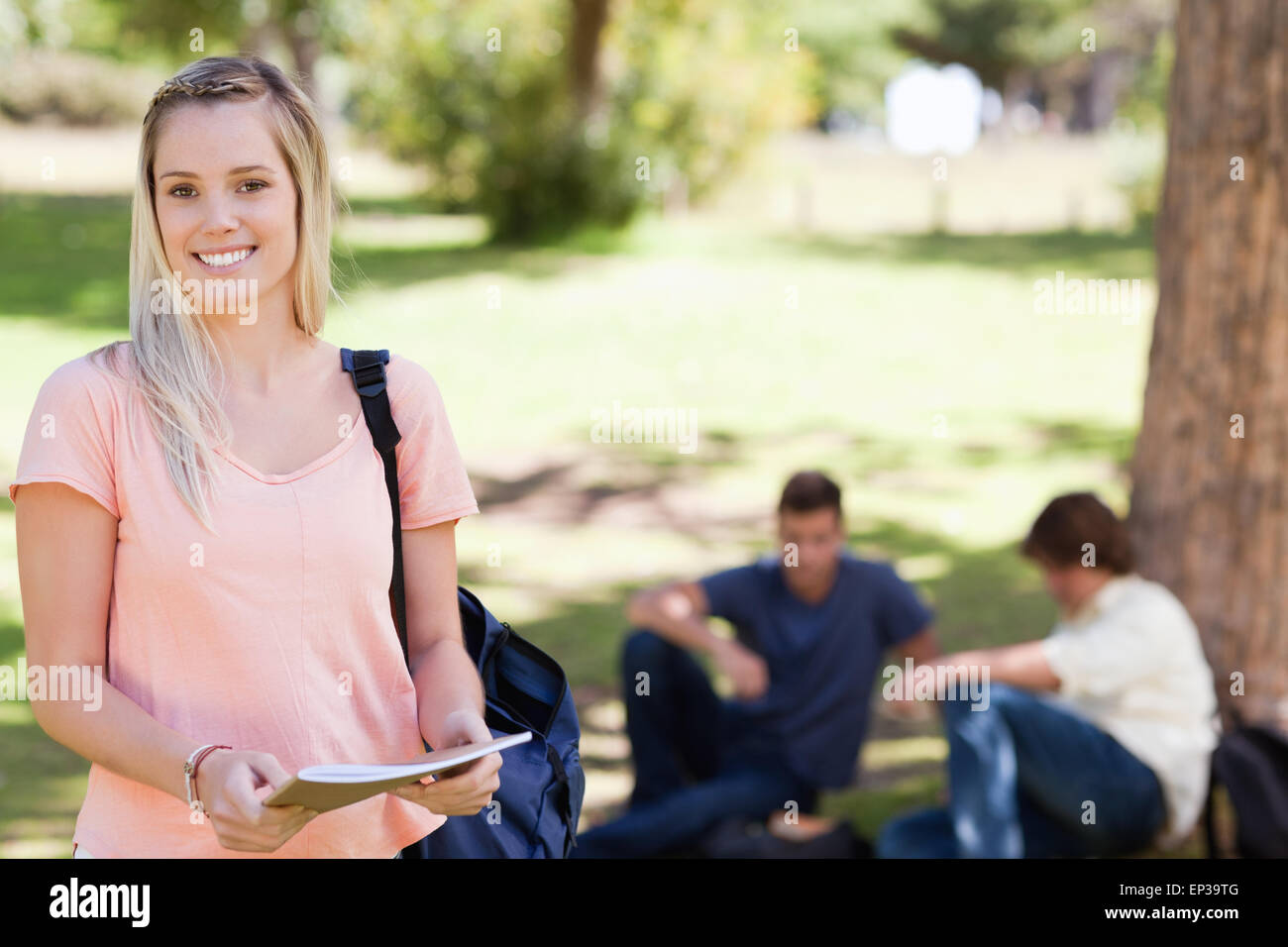 Portrait of a female student smiling while holding a textbook Stock ...