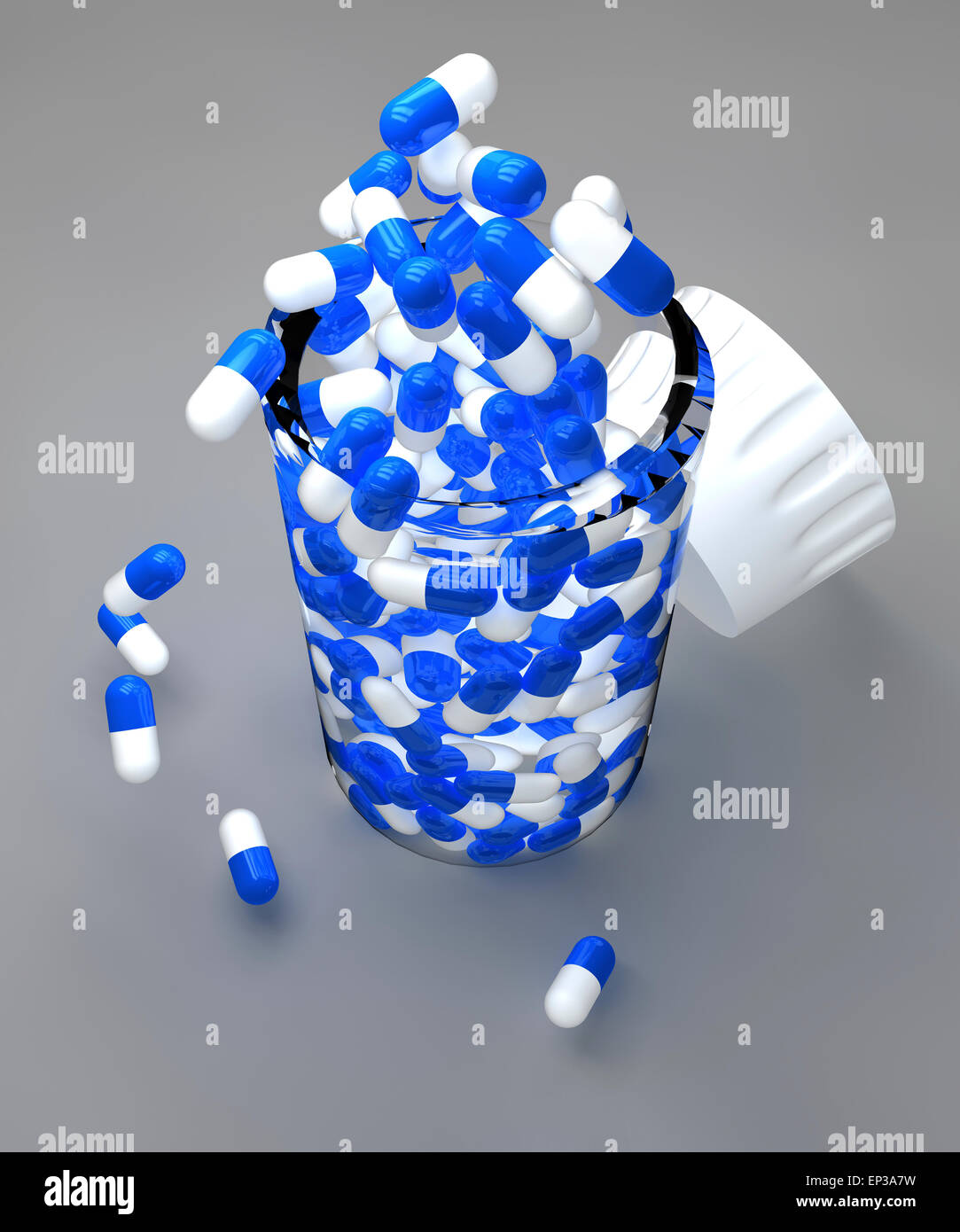 Blue and white pills in bottle on gray background Stock Photo