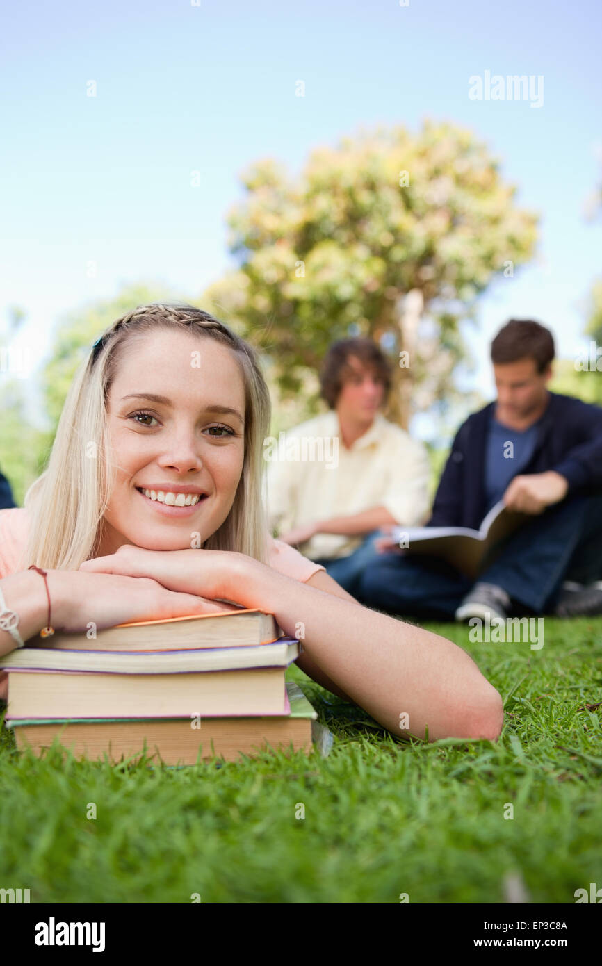 Close-up of a girl lying head on her books in a park Stock Photo - Alamy