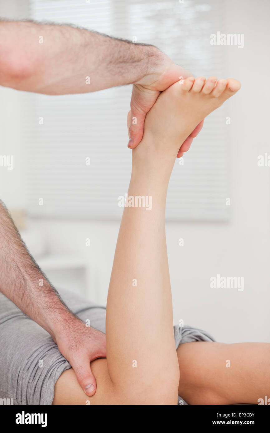 Woman lying forward while her doctor is manipulating her leg Stock ...