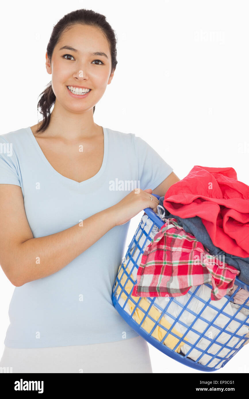 Smiling woman holding a basket full of laundry Stock Photo - Alamy