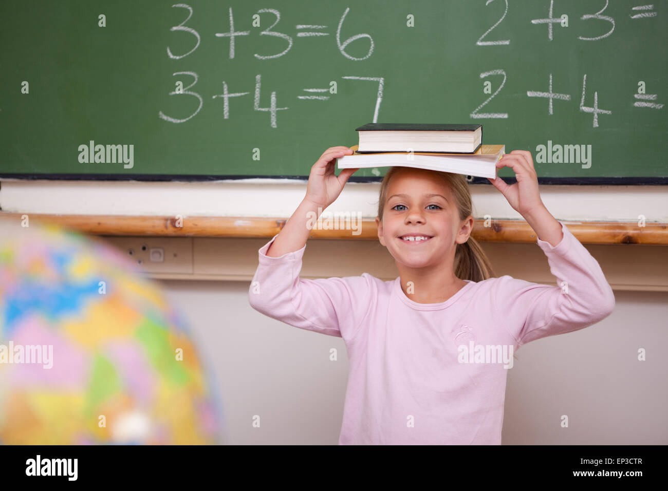Cute schoolgirl holding her book on her head Stock Photo - Alamy
