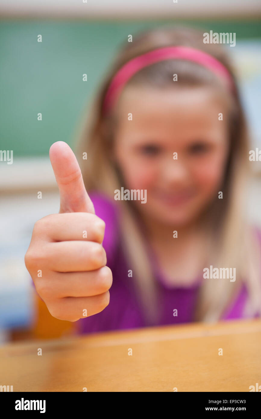Portrait of a cute schoolgirl with the thumb up Stock Photo - Alamy