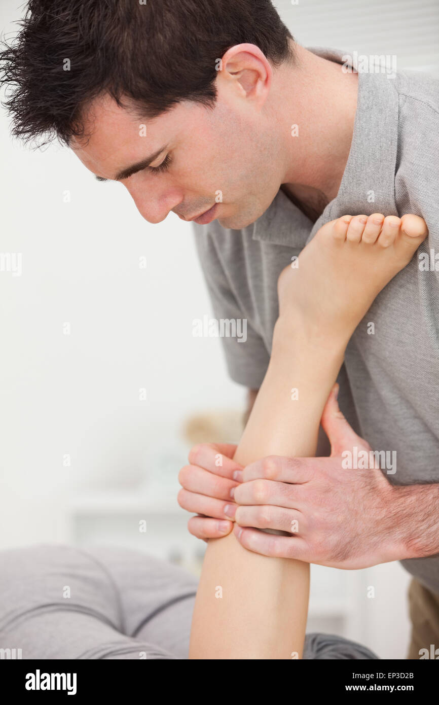 Woman lying while a physiotherapist is manipulating her leg Stock Photo ...
