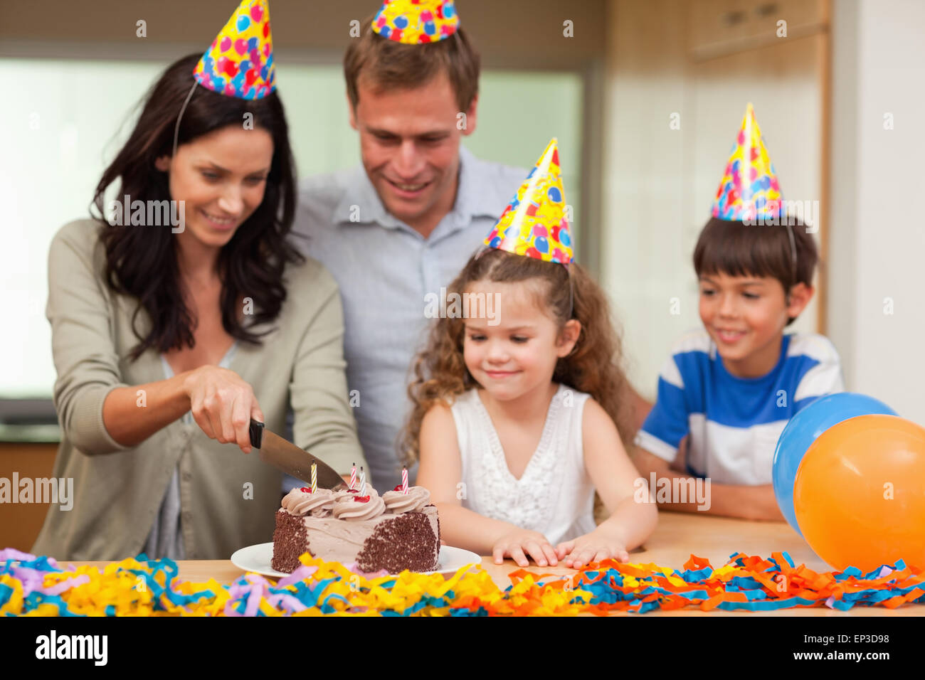 Mother cutting birthday cake Stock Photo
