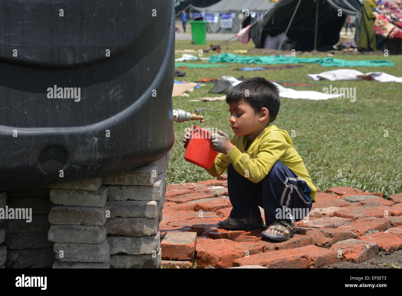Kathmandu, Nepal. 13th May, 2015. A child plays beside tents in quake-hit Kathmandu, Nepal, May 13, 2015. © Liu Chuntao/Xinhua/Alamy Live News Stock Photo