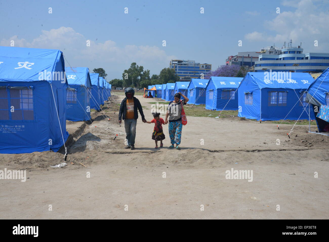 Kathmandu, Nepal. 13th May, 2015. People walk past tents donated by China in quake-hit Kathmandu, Nepal, May 13, 2015. © Liu Chuntao/Xinhua/Alamy Live News Stock Photo