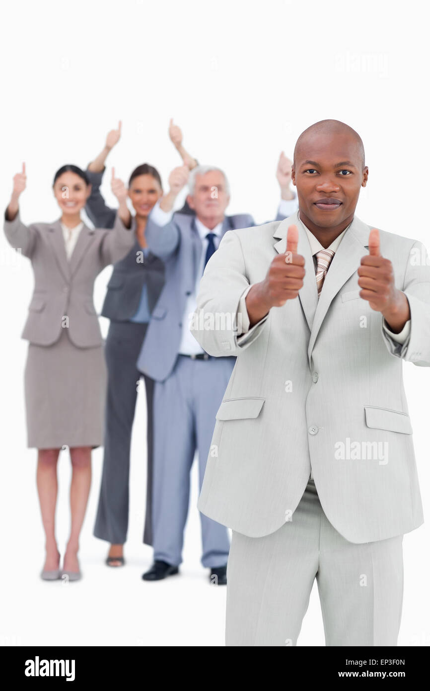 Tradesman with cheering team behind him giving thumbs up Stock Photo ...