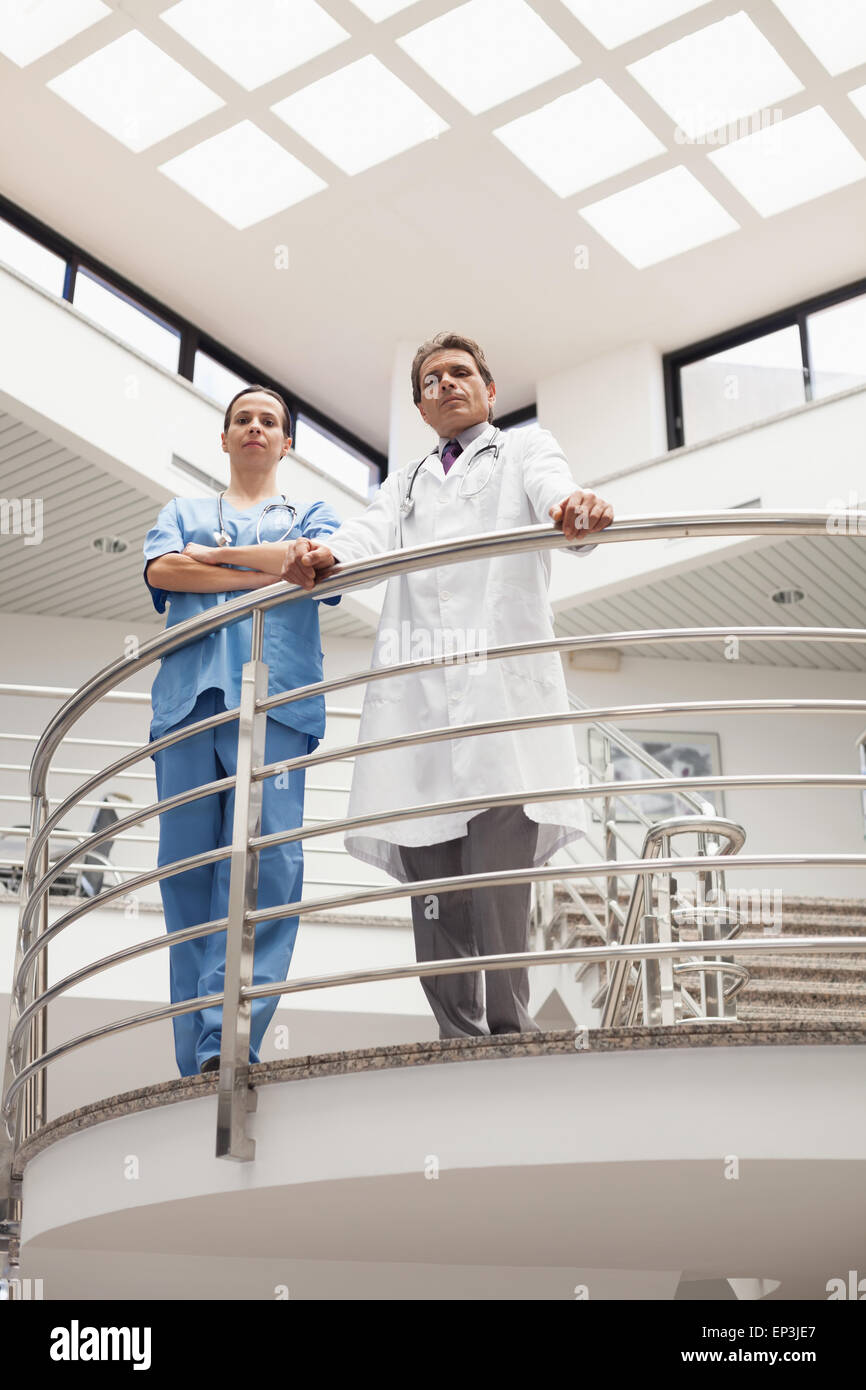 Nurse and doctor standing earnestly at the stairwell Stock Photo