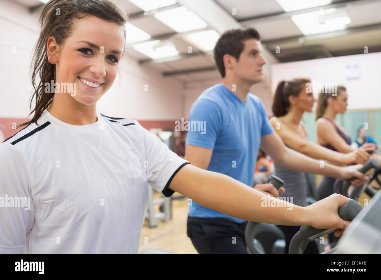 Smiling brunette with other people on a step machine Stock Photo - Alamy