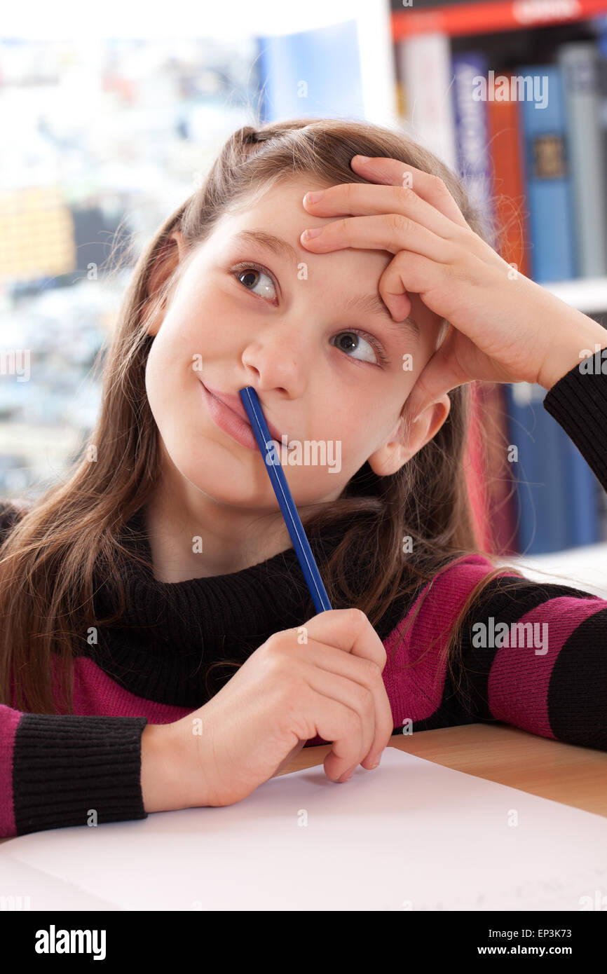 Mädchen macht Hausaufgaben und denkt nach Stock Photo