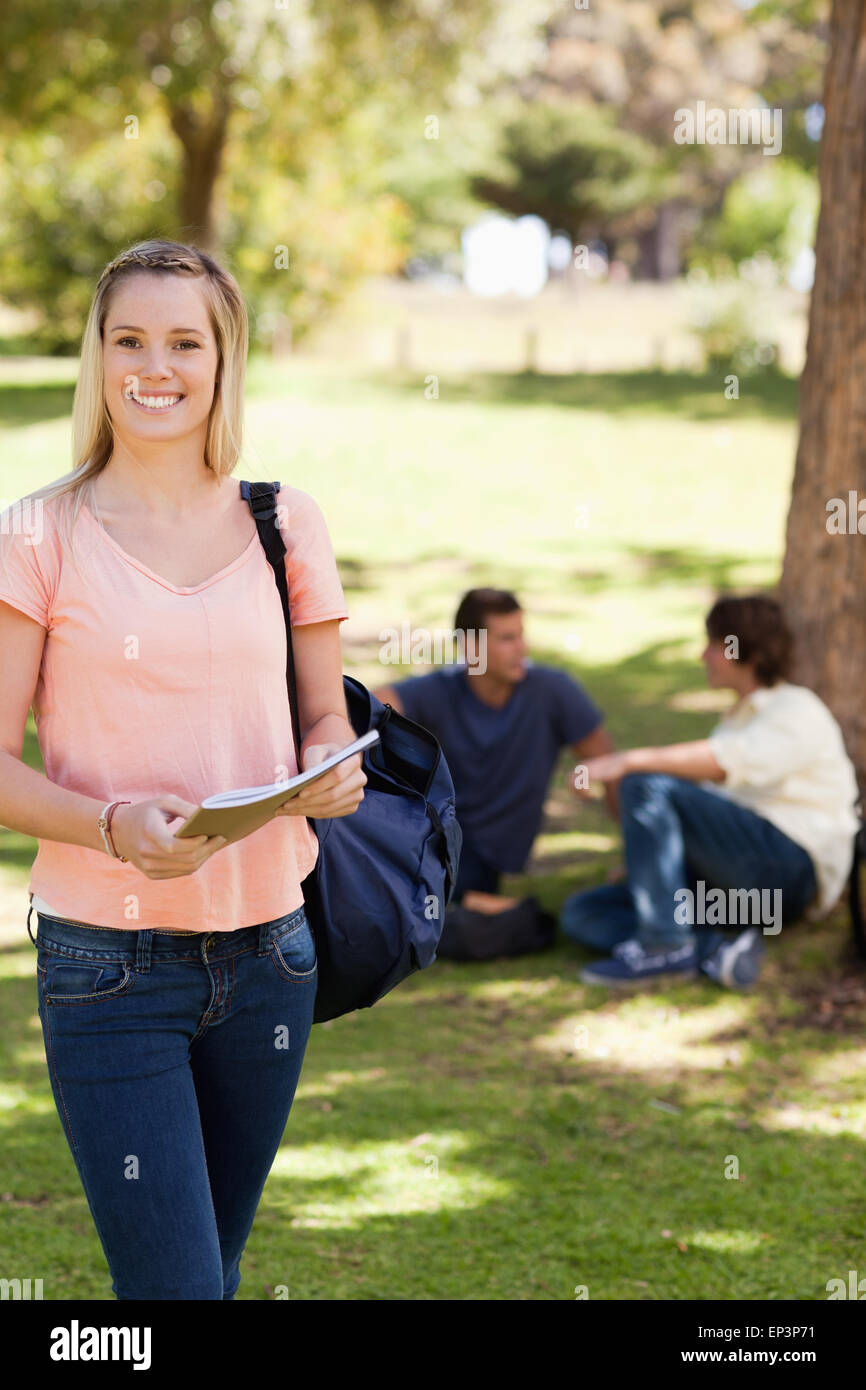Portrait of a smiling female holding a textbook Stock Photo - Alamy