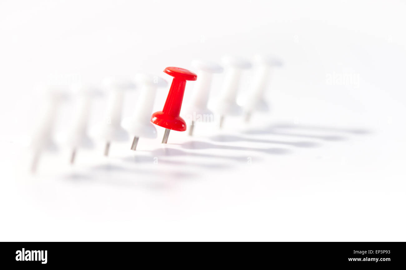 Red push pin in the middle of white push pins Stock Photo