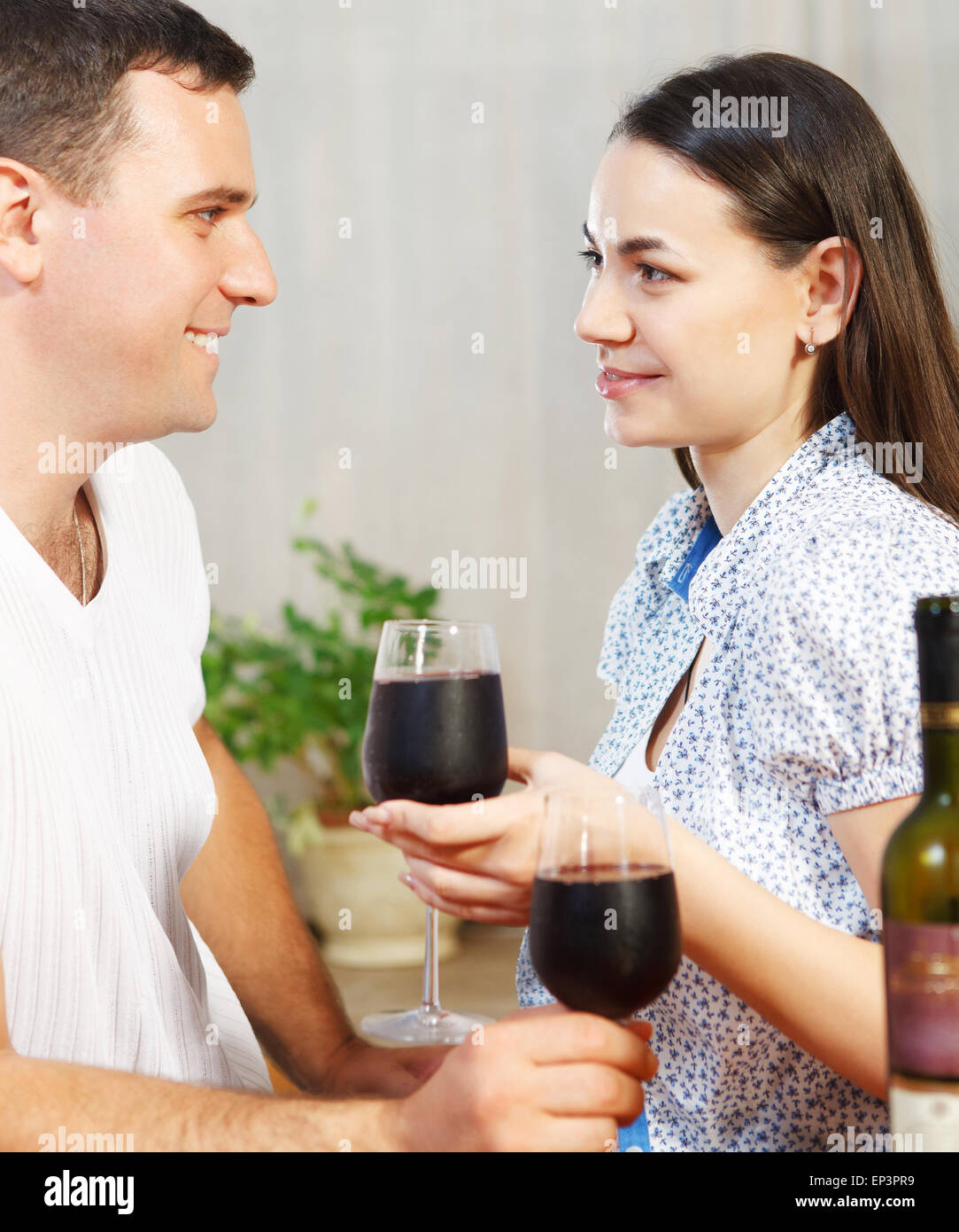 Young happy couple enjoying a glasses of red wine Stock Photo - Alamy