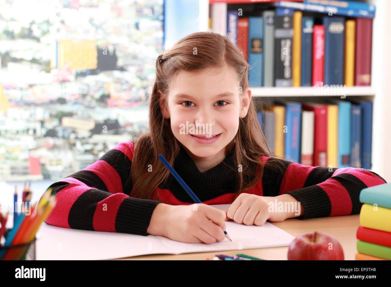 Mädchen macht Hausaufgaben und lächelt Stock Photo